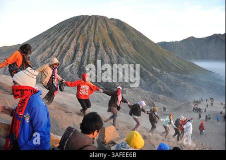 4 août 2012 - Probolinggo, Java oriental, Indonésie - les touristes locaux sur les pentes du mont bromo vont main dans la main en raison de la zone autour du bromo glissante avec du sable. . Beaucoup de touristes viennent voir la cérémonie de Yadnya Kasada. Yadnya Kasada cérémonie organisée par le Tenggerese hindou anually dans le temple Luhur Poten, zone sacrée au mont bromo mer de sable. Les Tenggerese donnèrent des offrandes à Dieu sous de nombreuses formes, sajenan, suguhan et tassement. Kasada est l'un des fameux agenda touristique de l'Indonésie qui pourrait attirer les touristes nationaux et étrangers venir à bromo. (Crédit image : © Robertus Pudyanto/ZUMAPRESS.com) Banque D'Images