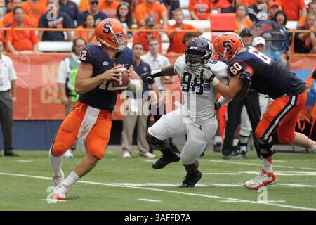 1er septembre 2012 - Syracuse, New York, U. S - le quarterback de Syracuse Orange RYAN NASSIB (12) roule loin de la persuasion par le joueur de ligne défensive DEONTE GIBSON (98) de Northwestern Wildcats alors que Syracuse Orange attaque SEAN HICKEY (60) bloke dans le quatrième quart-temps au Carrier Dome à Syracuse, New York. Northwestern s'accroche pour vaincre Syracuse par un score de 42-41. (Crédit image : © Michael Johnson/ZUMAPRESS.com) Banque D'Images