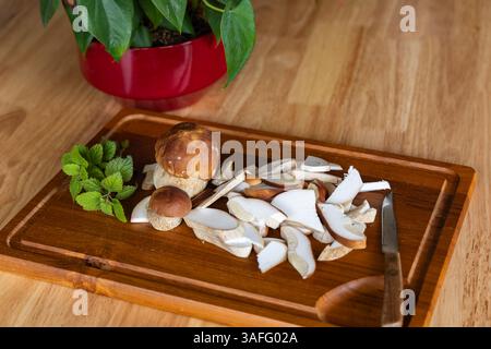 Les champignons boletus frais sont préparés pour la cuisson sur une planche à découper dans la cuisine Banque D'Images