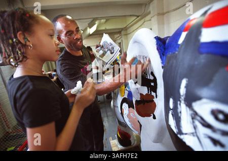 Le professeur d'art Gary Coletrane travaille avec Rickeya McClain, 10 ans, alors qu'elle et d'autres jeunes participent à la peinture de deux des ''Party Animals'' au Boys and Girls Club of Greater Washington, mercredi matin, 3 avril 2002. Les sculptures seront éventuellement exposées au Reagan Building. (Crédit image : The Washington Times/ZUMAPRESS.com) Banque D'Images