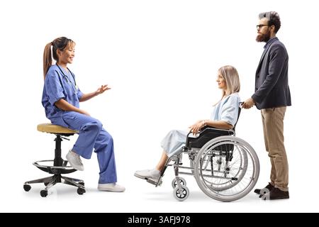 Médecin asiatique parlant à une jeune patiente dans un fauteuil roulant isolé sur fond blanc Banque D'Images