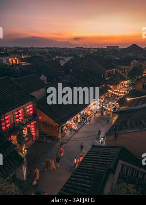 Le crépuscule doré baigne les rues historiques de Hoi an, Vietnam, tandis que les allées éclairées par des lanternes et l'énergie animée créent une ambiance enchanteresse et inoubliable Banque D'Images