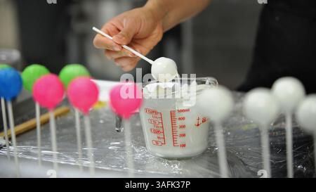 8 mai 2012 - Walnut Creek, CA, États-Unis - Paulina Tsagaris, de Sweet Luna desserts, trempe des gâteaux dans une forme fondue de chocolat blanc dans son espace de travail de cuisine à Campbell, Californie, le mercredi 9 mai 2012 (image de crédit : Dan Honda/MCT/ZUMAPRESS.com) Banque D'Images