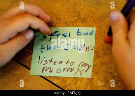 LÉGENDE : (06/10/2005 LAND O'LAKES). RÉSUMÉ DE L'HISTOIRE : un enfant écrit un regret lors d'un camp de deuil fourni par Hernando-Pasco Hospice pour les enfants d'âge primaire qui avaient perdu des êtres chers. Les enfants ont été encouragés à noter tous leurs regrets et ils les ont jetés dans un bol pour être détruits. (On peut lire : je me sens mal de ne pas avoir écouté ma mère) (crédit image : St Petersburg Times/ZUMAPRESS.com) Banque D'Images
