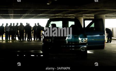 Tampa, 27/06/2005) PHOTO 3 : les enquêteurs regardent la scène d'une fusillade au septième étage du parking de courte durée de l'aéroport international de Tampa. Trois policiers de l'aéroport ont vu un homme tirer sur une femme, puis il a commencé à tirer sur les policiers. Ils ont blessé l'homme armé, qui a été emmené à l'hôpital. La femme est morte sur les lieux. RÉSUMÉ DE L'HISTOIRE : tournage dans le garage de stationnement à court terme de l'aéroport international de Tampa, niveau sept. Une femme a été tuée par un homme armé, l'homme armé a été blessé par la police de l'aéroport de Tampa qui l'a vu tuer la femme non identifiée. (Crédit image : Saint-Pétersbourg Banque D'Images