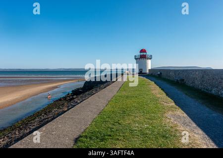 Le phare de Burry Port se dresse sur le brise-lames à l'entrée du port de Burryport dans le Carmarthenshire au sud du pays de Galles. Vu contre un ciel bleu. Banque D'Images