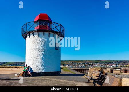 Le phare de Burry Port se dresse sur le brise-lames à l'entrée du port de Burryport dans le Carmarthenshire au sud du pays de Galles. Vu contre un ciel bleu. Banque D'Images
