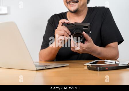 Appareil photo et plusieurs lentilles de caméra sur la table basse. Bonne vie de retraite, passe-temps et intérêts pour les personnes âgées concept. Homme asiatique senior nettoyage et ch Banque D'Images
