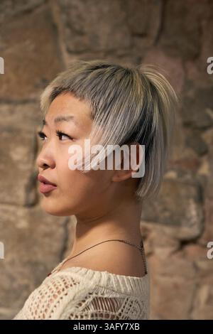 Jeune femme asiatique montrant un style de cheveux argenté court à la mode Banque D'Images