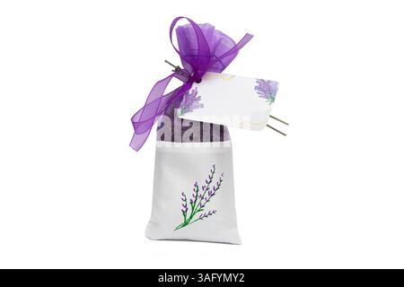 Un petit sac rempli de fleurs de lavande parfumées sur fond blanc. Le sac a également une note sur laquelle vous pouvez écrire quelques mots. Cadeau de mariage. Banque D'Images