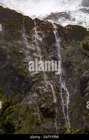 Paysage de Patagonie dynamique : ruisseau serein et cascade au milieu des rochers avec de la mousse de couleur rouille. Des teintes chaudes contrastent avec une végétation luxuriante et un Wate limpide Banque D'Images