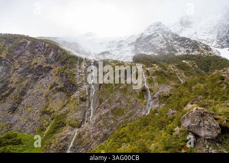 Paysage de Patagonie dynamique : ruisseau serein et cascade au milieu des rochers avec de la mousse de couleur rouille. Des teintes chaudes contrastent avec une végétation luxuriante et un Wate limpide Banque D'Images