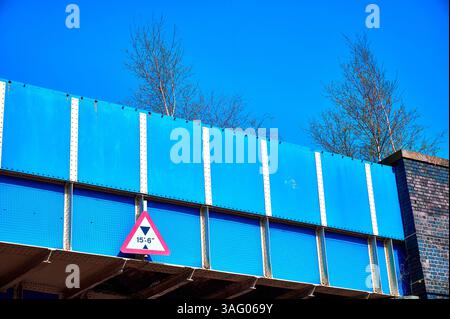 Panneau de restriction de hauteur sous le pont de chemin de fer bleu Banque D'Images