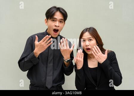 Portrait d'un jeune couple asiatique portant un uniforme d'affaires sur fond Uni Banque D'Images