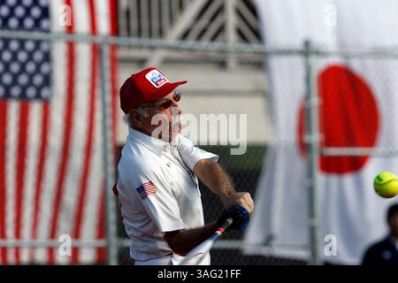 48- LÉGENDE : (Honolulu 12/19/07).Kids and Kubs joueur de softball des États-Unis et vétéran de la Garde côtière Irv Abelson (cq), 82 ans, se connecte tout en battant à la plaque alors que les drapeaux des États-Unis et du Japon pendent à une clôture sur le troisième côté de base du terrain, tout en jouant contre l'équipe japonaise de softball Over the Rainbows au terrain Hans L'Orange à Honolulu, Hawaï, mercredi après-19/07. Les Kids et Kubs ont ensuite gagné avec un score final de 14 à 2. RÉSUMÉ DE L'HISTOIRE : pour 1A Story à courir Dec. 19 -- les membres des Kids et Kubs qui ont combattu dans le théâtre Pacifique de la seconde Guerre mondiale voyagent Banque D'Images