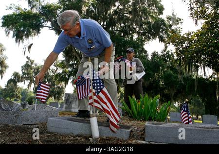 LÉGENDE : (Dade City 05/21/2008) Edward Gorecki (cq) un résident de Dade City et un agent d'application de la loi à temps partiel et vétéran de la Force aérienne place un drapeau sur la tombe d'un vétéran au cimetière de Dade City tandis que la gardienne du cimetière Mariarose Kussler se tient derrière lui avec une presse-papiers des tombes des vétérans et un bras plein de drapeaux américains. .. (Crédit image : St Petersburg Times/ZUMAPRESS.com) Banque D'Images