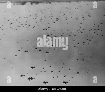 La préparation de l'invasion remplit le ciel de parachutistes -- le ciel au-dessus de cette base non identifiée quelque part en Angleterre est rempli de parachutistes et de parachutes transportant leurs provisions pendant les manœuvres pré-invasion. Plus de 1500 hommes ont pris part à ce test, considéré par l'armée comme probablement le plus grand saut d'exposition de masse jamais effectué par ses forces. Les avions (en haut) qui transportaient les parachutistes sont des C-47 26 juin 1944. (Photo de AP Wirephoto). Banque D'Images