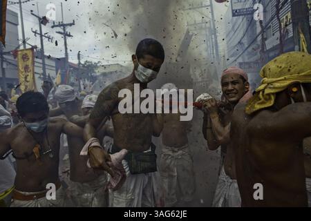 24 octobre 2009 - Phuket, Thai - des feux d'artifice explosent au-dessus des statues des Dieux empereurs chinois portées par des dévots lors de cérémonies au Festival végétarien de Phuket, Thaïlande. Les dévots s'abstiennent de manger de la viande pendant le festival de dix jours et croient qu'en se faisant percer, en marchant sur des charbons chauds et d'autres actes d'auto mortification, ils font du mérite et prennent sur les péchés de leur communauté. (Crédit image : © David Longstreath/ZUMAPRESS.com) Banque D'Images