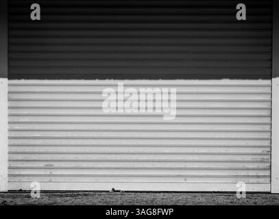 Lumière divisée : ombres et soleil sur porte de garage blanche Banque D'Images