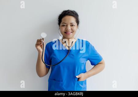Portrait d'infirmière afro-américaine ou médecin dans les gommages tenant le stéthoscope Banque D'Images