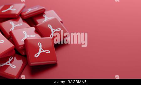 Gros plan du logo du logiciel Adobe Acrobat sur une pile sur fond rouge avec un espace de copie comme en-tête de bannière Web Banque D'Images