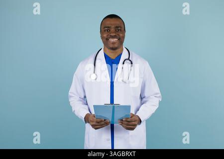 Sourire jeune Noir Docteur homme en uniforme avec presse-papiers dans les mains Banque D'Images