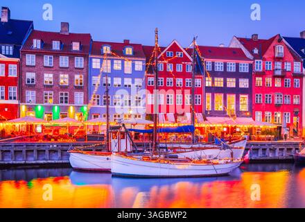 Copenhague, Danemark. Nyhavn. canal d'eau emblématique dans le crépuscule coloré du matin avec des reflets d'eau à couper le souffle. Banque D'Images
