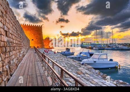 Héraklion, Grèce. Vieux port avec bateaux de pêche et port de plaisance pendant l'heure bleue crépusculaire, île de Crète. Les bateaux brouillaient le mouvement au premier plan. Banque D'Images