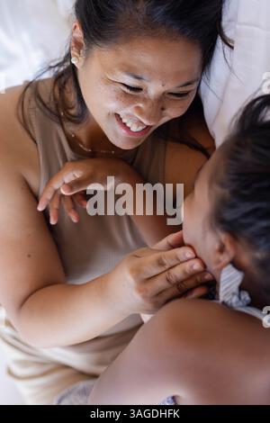 Mère et fille riant ensemble, profitant du temps de liaison à la maison. Famille, ensemble, bonheur, loisirs, amour, relation Banque D'Images