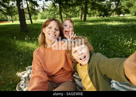POV Happy Mother et Two Boys prenant Selfie photo sur couverture dans le parc Banque D'Images
