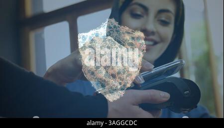 Image d'un réseau de connexions avec bouclier de sécurité sur les personnes utilisant un terminal de paiement Banque D'Images