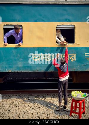 Vendeur de rue vendant des collations aux passagers du train, gare de Tongi à côté de Dhaka Banglades Banque D'Images