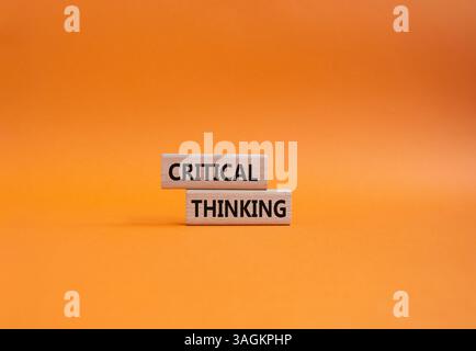 Symbole de pensée critique. Blocs en bois avec des mots pensée critique. Beau fond orange. Concept d'entreprise et de pensée critique. Copier l'espace. Banque D'Images