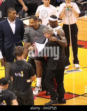 19 juin 2012 - Miami, FL, États-Unis - LeBron James du Heat de Miami est porté par Juwan Howard, à gauche, et l'entraîneur sportif/coordinateur de voyage Jay Sabol, à droite, lors du quatrième quart-temps du match 4 de la finale de la NBA à AmericanAirlines Arena à Miami, Floride, le mardi 19 juin 2012. (Crédit image : © David Santiago/El Nuevo Herald/MCT/ZUMAPRESS.com) Banque D'Images