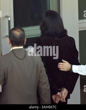 20 novembre 2003 ; Santa Barbara, CA, États-Unis ; Michael Jackson menotté, est emmené dans la prison du comté de Santa Barbara pour être réservé sur des accusations d'agression d'enfant. Jackson procéda pour faire la caution d'un million et retourna à Las Vegas. Jackson nie les accusations de multiples chefs d'accusation de conduite obscène avec un enfant de moins de 14 ans. Banque D'Images