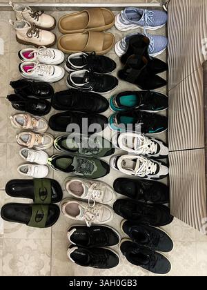 Kiev, Ukraine - 08 avril 2025 : une collection soigneusement arrangée de divers types de chaussures et de chaussures sur une surface carrelée. Banque D'Images