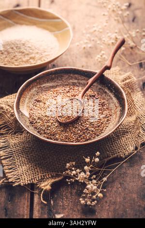 Graines de lin râpées et tas de balle de psyllium (Isabgol) dans un bol sur une table en bois Banque D'Images