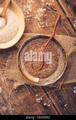 Graines de lin râpées et tas de balle de psyllium (Isabgol) dans un bol sur une table en bois Banque D'Images
