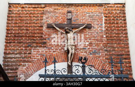 LVIV, UKRAINE - 20 juin 2021 : murs de briques historiques et architecture, à côté d'un crucifix, mettent en valeur le riche patrimoine culturel et religieux de la ville au milieu de rues animées. Banque D'Images