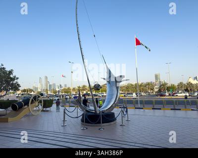 22 mars 2025. Émirats arabes Unis. Abu Dhabi. Sculpture Swordfish à l'entrée de Marina Mall. Drapeau des Émirats arabes Unis agitant Banque D'Images