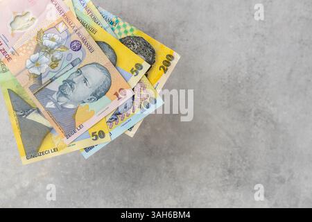 Roumanie argent, homme d'affaires met une poignée de billets de banque lei roumains sur une table grise, Business et concept économique, finances roumaines, espace de copie Banque D'Images