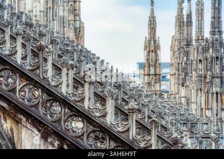 Vue sur les flèches et statues gothiques ornant le toit de la cathédrale de Milan (Duomo di Milano) en Italie. Banque D'Images