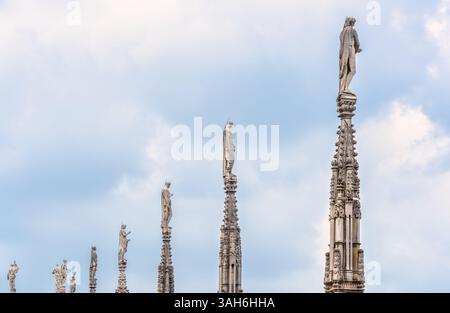 Vue sur les flèches et statues gothiques ornant le toit de la cathédrale de Milan (Duomo di Milano) en Italie. Banque D'Images