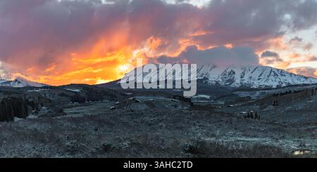 Au coucher du soleil, des nuages brillants recouvrent la chaîne Anthracite près de Gunnison et Crested Butte Colorado. Un saupoudrage de neige a recouvert le feuillage émergent. Banque D'Images