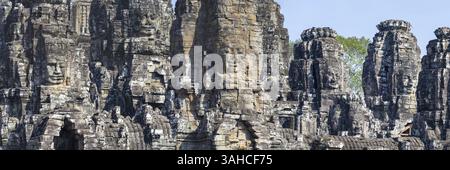 Image panoramique des visages géants sculptés dans la pierre du Bodhisattva Lokeshvara, également connu sous le nom d'Avalokiteshvara, Temple du Bayon, Angkor Thom, UNESCO World Heri Banque D'Images