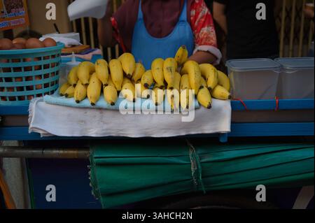 Bananes fraîches soigneusement exposées sur le chariot d'un vendeur ambulant Banque D'Images