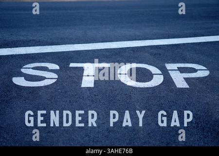arrêtez le concept d'écart de rémunération entre les sexes. mots écrits sur l'asphalte à un panneau d'arrêt d'autoroute. Banque D'Images