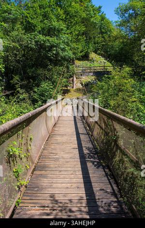 Passerelle suspendue avec tablier en bois, supports de câble en acier. Il traverse le canyon de Cosa Torrente aux grottes de Grotte di Pradis, Pradis di Sotto, Italie Banque D'Images