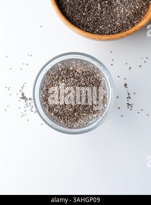 Graines de chia dans un verre plein d'eau. Vue de dessus. Verre d'eau avec des graines de chia isolé sur fond blanc. Banque D'Images