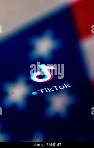 Schwerin, Allemagne. 10 avril 2025. Le logo de la plateforme vidéo TikTok, une application de médias sociaux de la société technologique chinoise Bytedance, apparaît sur un écran avec un reflet du drapeau américain. Aux États-Unis, une proposition législative est avancée qui pourrait obliger TikTok à se séparer de sa société mère chinoise ByteDance - sinon l'application pourrait être interdite du marché américain. Le président AMÉRICAIN Trump a prolongé de 75 jours la date limite pour la vente des activités américaines de TikTok afin de permettre la poursuite des négociations. Crédit : Jens Büttner/dpa/Alamy Live News Banque D'Images